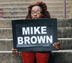 A person holding a sign that reads 'Mike Brown'.
